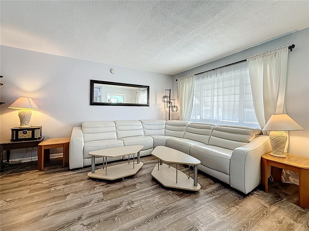 250 Rosery Road Northwest, Unit 228 Largo, FL 33770 - Photo 6 of 27 a living room with furniture and a large window
