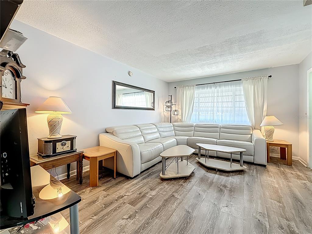 250 Rosery Road Northwest, Unit 228 Largo, FL 33770 - Photo 7 of 27 a living room with furniture and a wooden floor