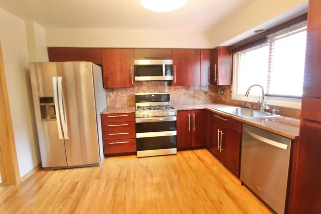 a kitchen with stainless steel appliances granite countertop a refrigerator and a sink