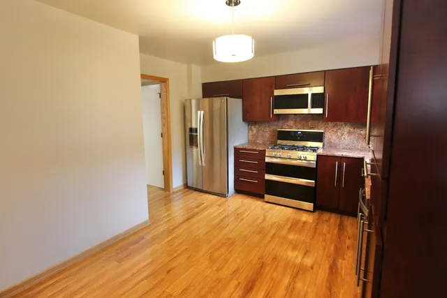 a kitchen with stainless steel appliances a refrigerator and a stove top oven