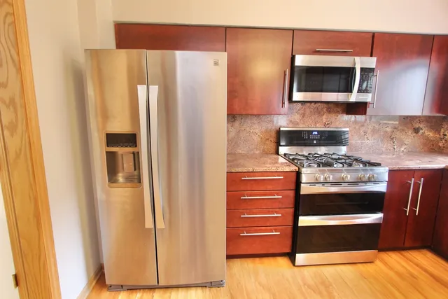 a kitchen with stainless steel appliances a refrigerator and a stove top oven