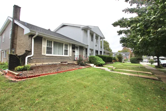 a front view of a house with a yard table and chairs