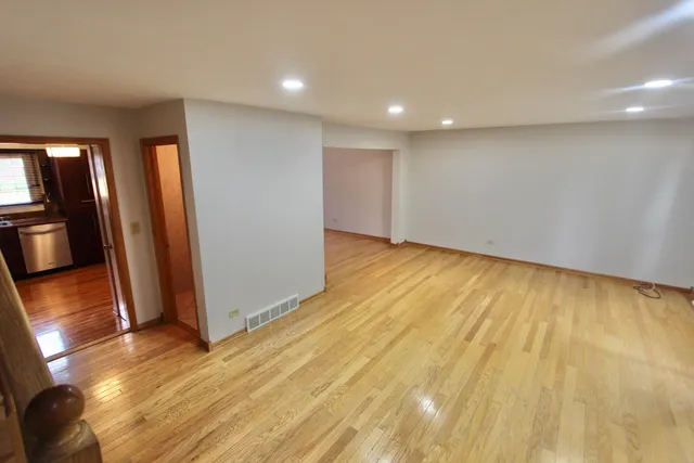 a view of a hallway with wooden floor and a small space