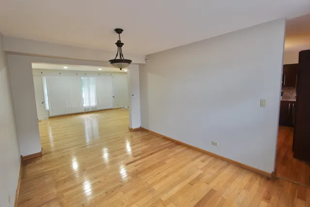 a view of a room with wooden floor and a ceiling fan