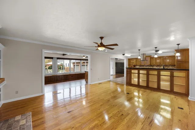 a view of an empty room with wooden floor fireplace and a window