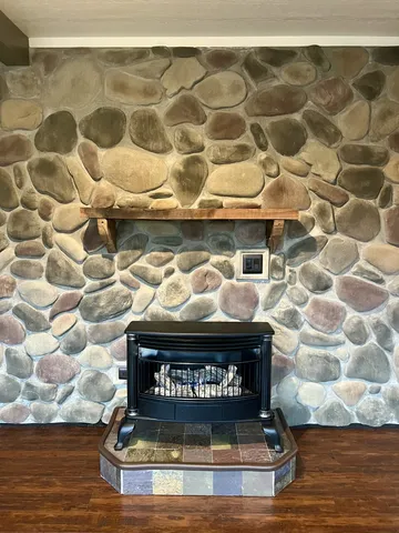 a view of a hallway to a bedroom with wooden floor and windows