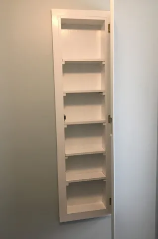 a view of walk in closet with wooden floor