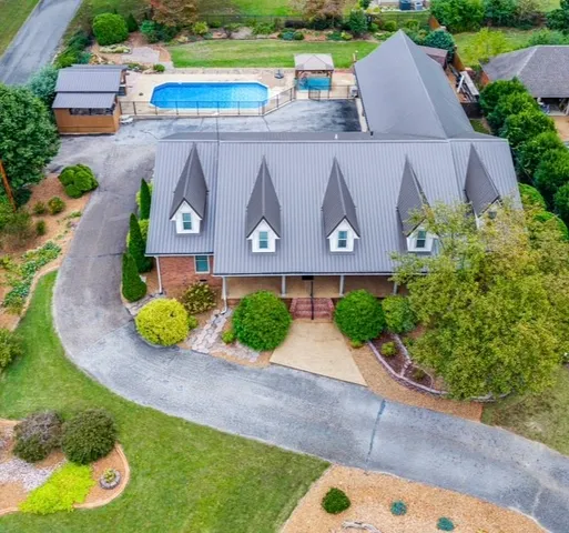 an aerial view of a house with a garden and swimming pool