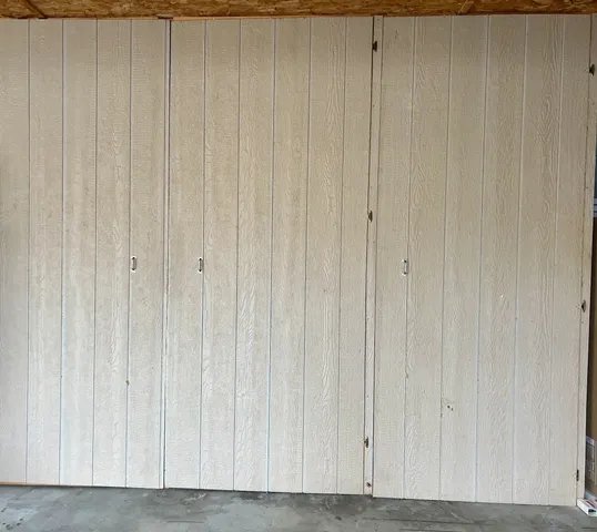 a view of a patio with a table and chairs under an umbrella with a small yard