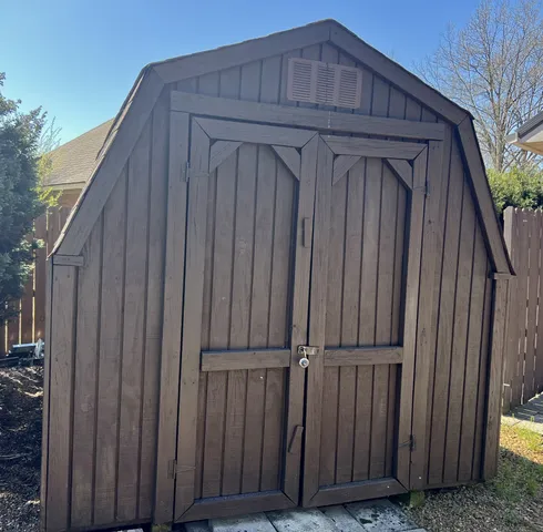 a view of a backyard with a fence and wooden fence