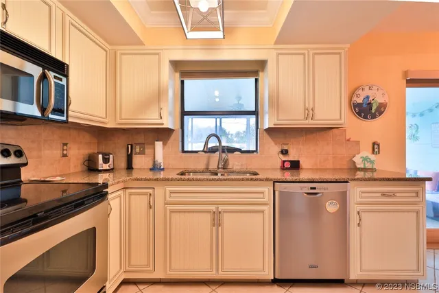 a kitchen with cabinets appliances a sink and a window