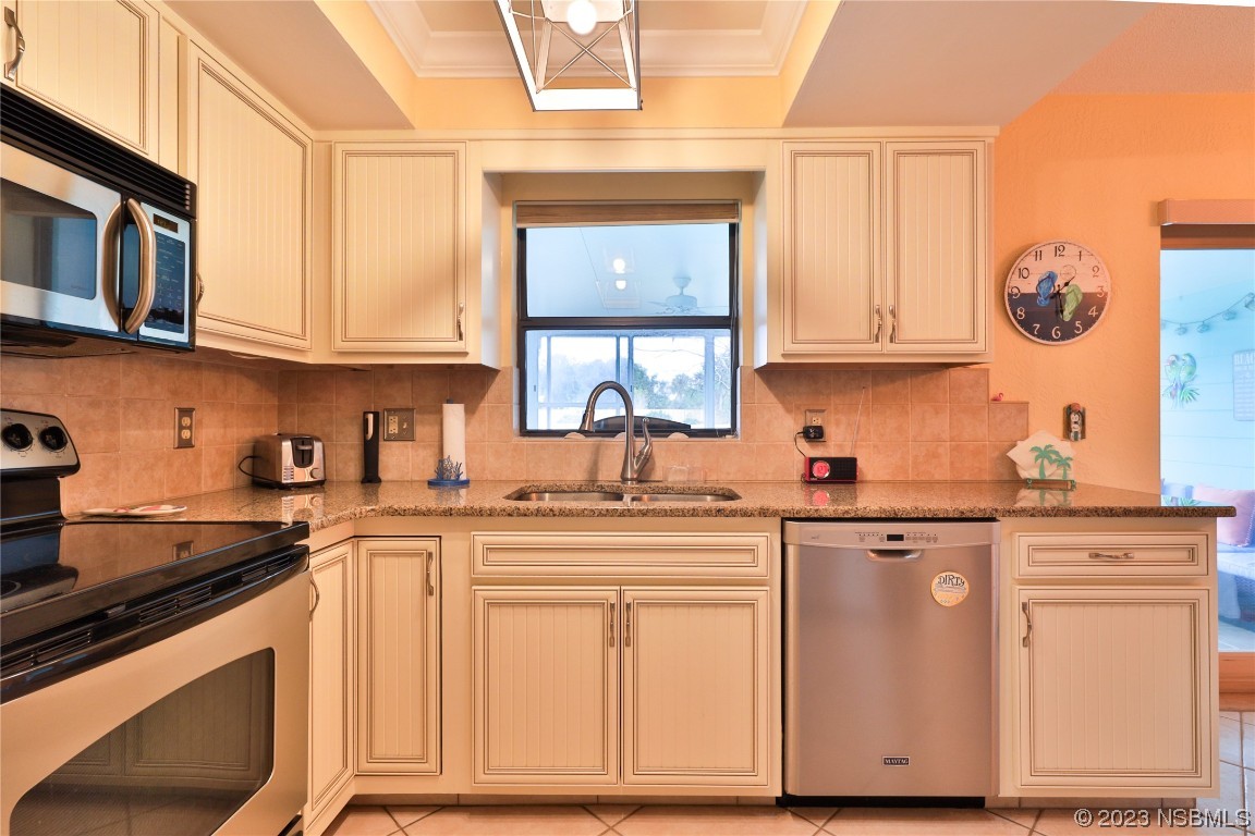 4701 South Peninsula Drive Ponce Inlet, FL 32127 - Photo 12 of 32 a kitchen with cabinets appliances a sink and a window