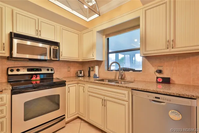 a kitchen with stainless steel appliances granite countertop a sink a stove microwave and cabinets