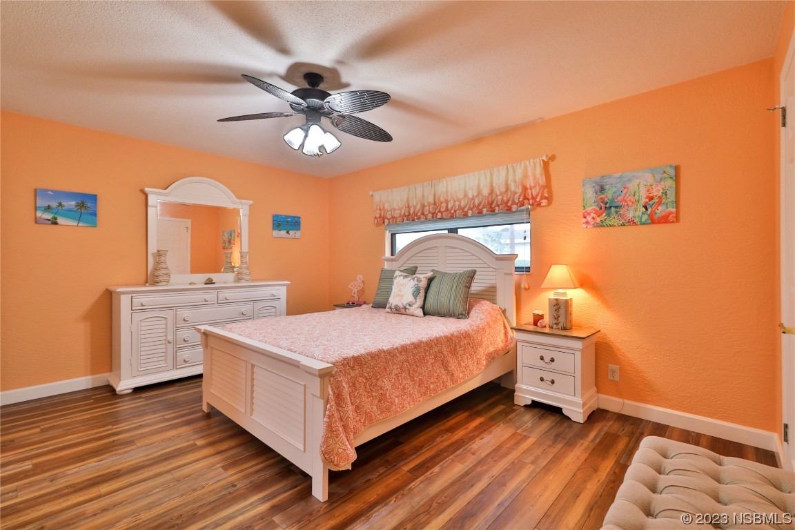 4701 South Peninsula Drive Ponce Inlet, FL 32127 - Photo 14 of 32 a bedroom with a bed and a chandelier