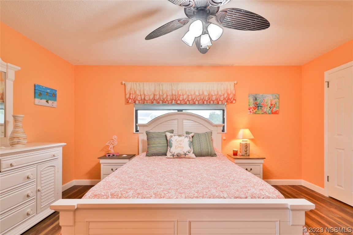 4701 South Peninsula Drive Ponce Inlet, FL 32127 - Photo 16 of 32 a bedroom with a bed and a chandelier