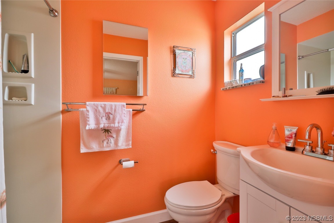 4701 South Peninsula Drive Ponce Inlet, FL 32127 - Photo 17 of 32 a bathroom with a toilet sink and mirror