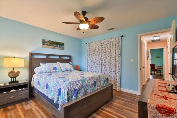 a bedroom with a bed and wooden floor