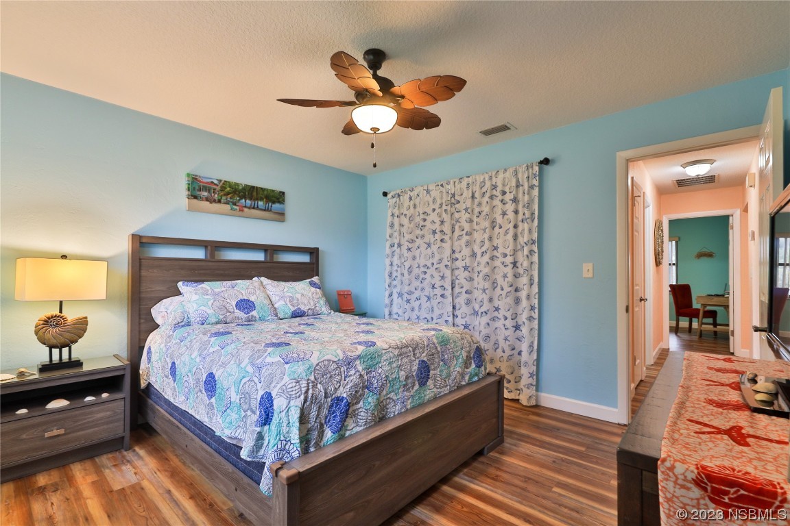 4701 South Peninsula Drive Ponce Inlet, FL 32127 - Photo 22 of 32 a bedroom with a bed and wooden floor
