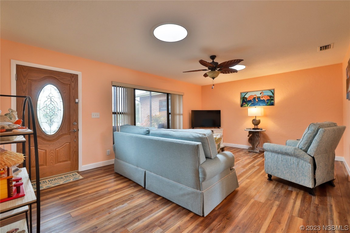 4701 South Peninsula Drive Ponce Inlet, FL 32127 - Photo 6 of 32 a living room with furniture a clock potted plant and a large window