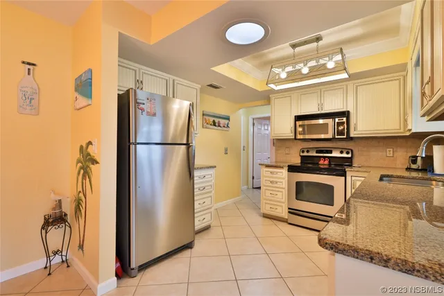 a kitchen with stainless steel appliances granite countertop a refrigerator a stove top oven a sink and dishwasher