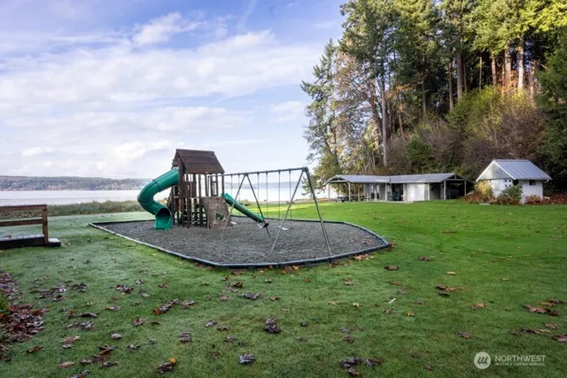 a front view of a house with garden and trees