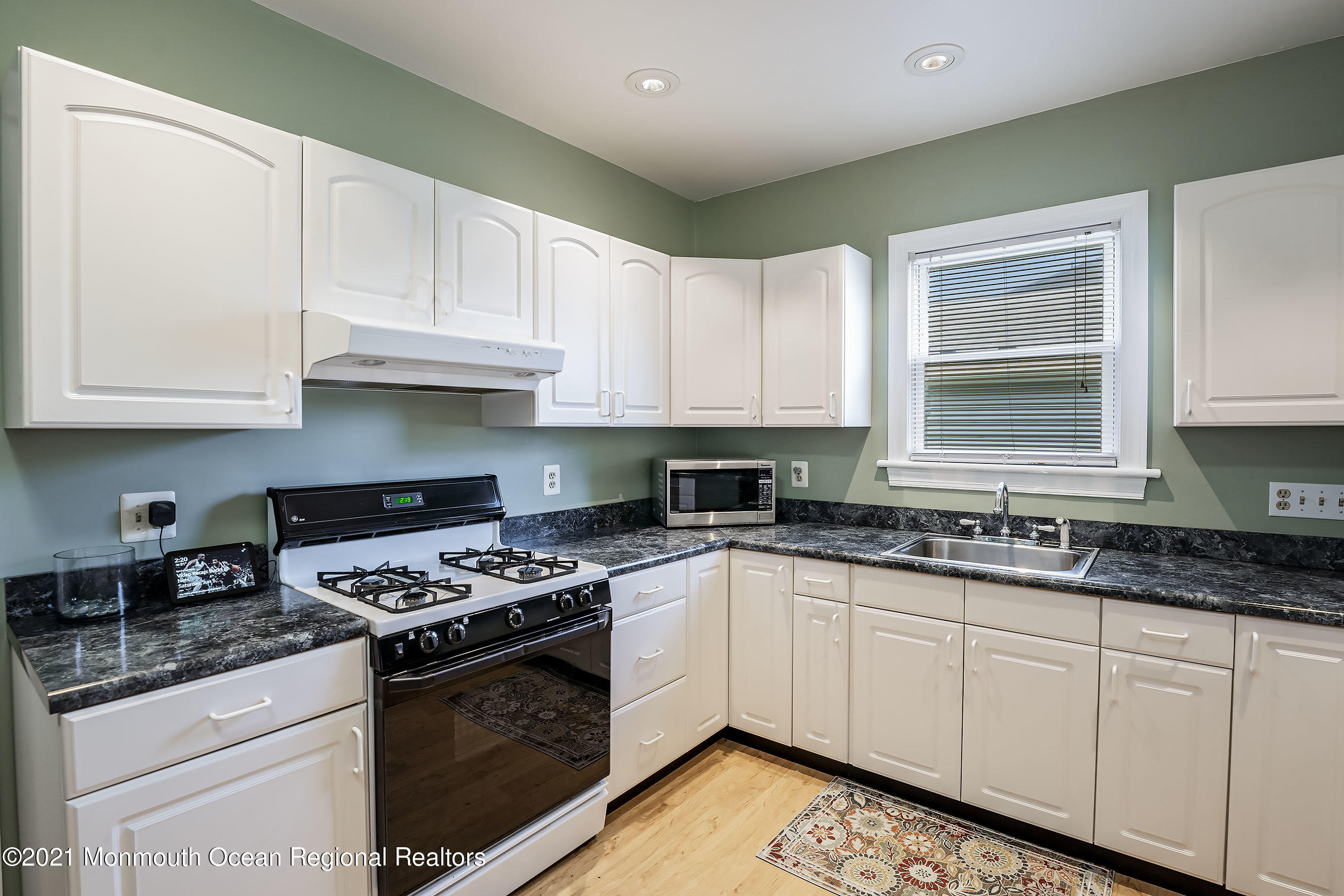 132 Sampson Place Long Branch, NJ 07740 - Photo 9 of 20 a kitchen with granite countertop white cabinets sink and stainless steel appliances
