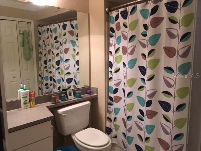 8939 Latrec Avenue, Unit 1205 Orlando, FL 32819 - Photo 5 of 15 a white toilet sitting next to a shower curtain