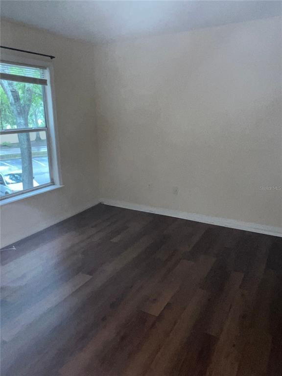 8939 Latrec Avenue, Unit 1205 Orlando, FL 32819 - Photo 6 of 15 an empty room with wooden floor and windows