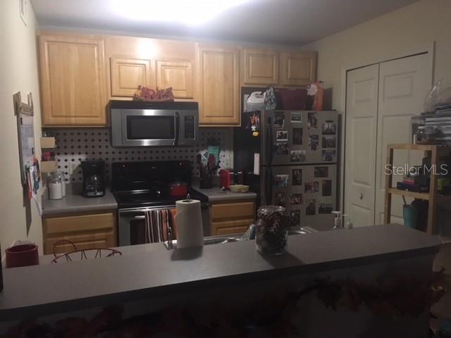 8939 Latrec Avenue, Unit 1205 Orlando, FL 32819 - Photo 7 of 15 a kitchen with a refrigerator and a stove