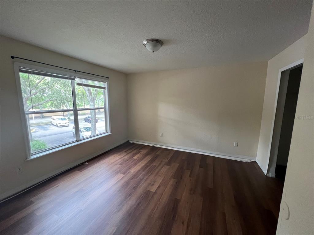 8939 Latrec Avenue, Unit 1205 Orlando, FL 32819 - Photo 10 of 15 an empty room with wooden floor and windows