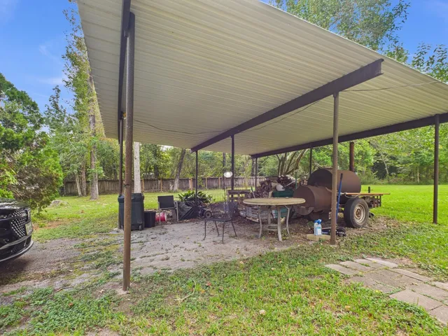 a view of a patio with table and chairs under an umbrella