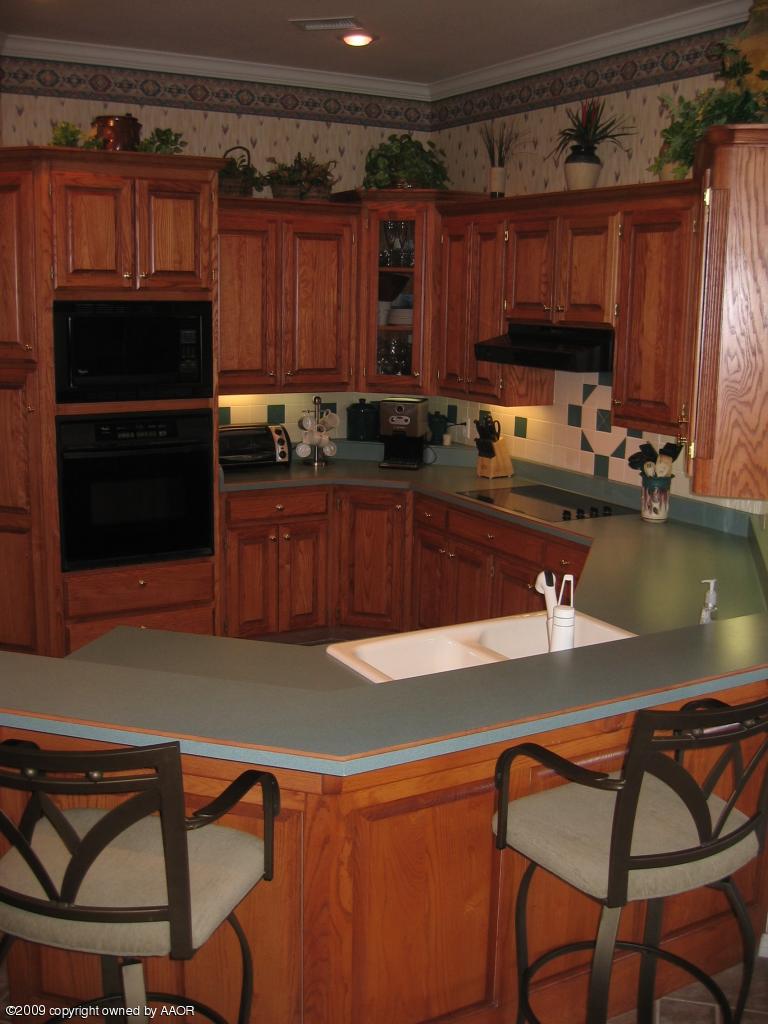 711 McKenzie Road Amarillo, TX 79118 - Photo 24 of 38 a kitchen with a table chairs stove and cabinets
