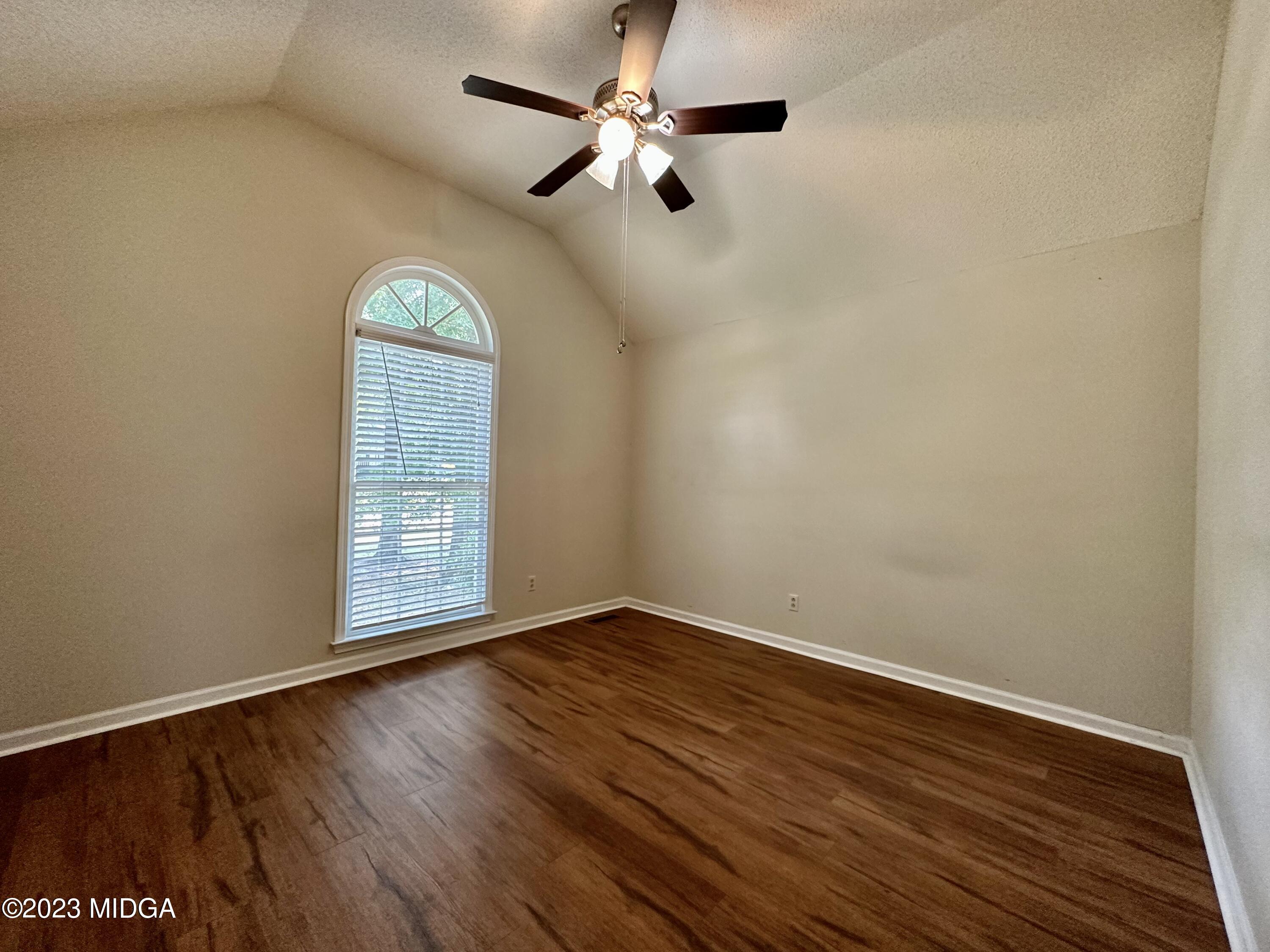 310 Old Oak Road Macon, GA 31216 - Photo 20 of 27 an empty room with wooden floor chandelier fan and windows