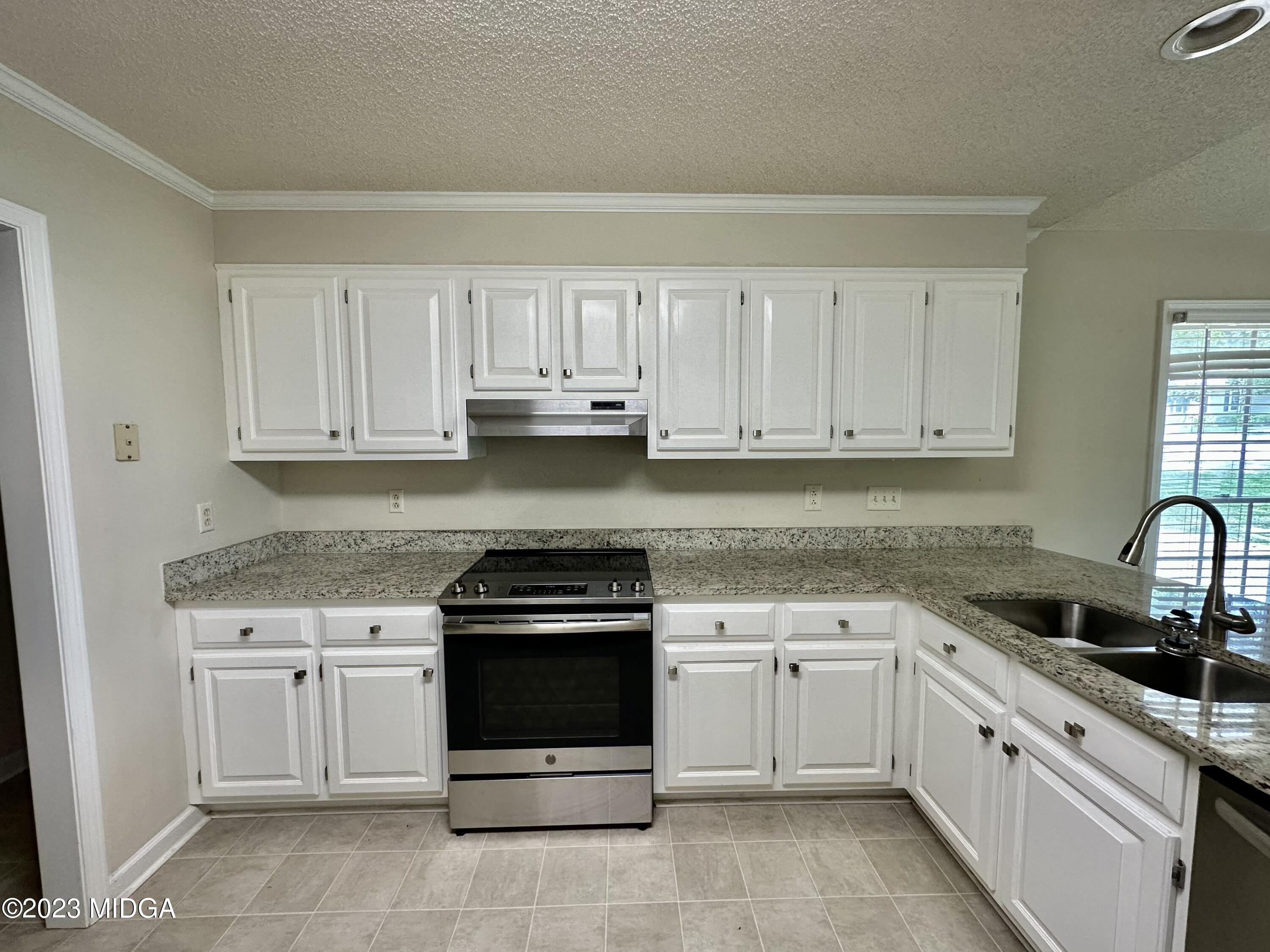310 Old Oak Road Macon, GA 31216 - Photo 6 of 27 a white kitchen with granite top and stainless steel appliances
