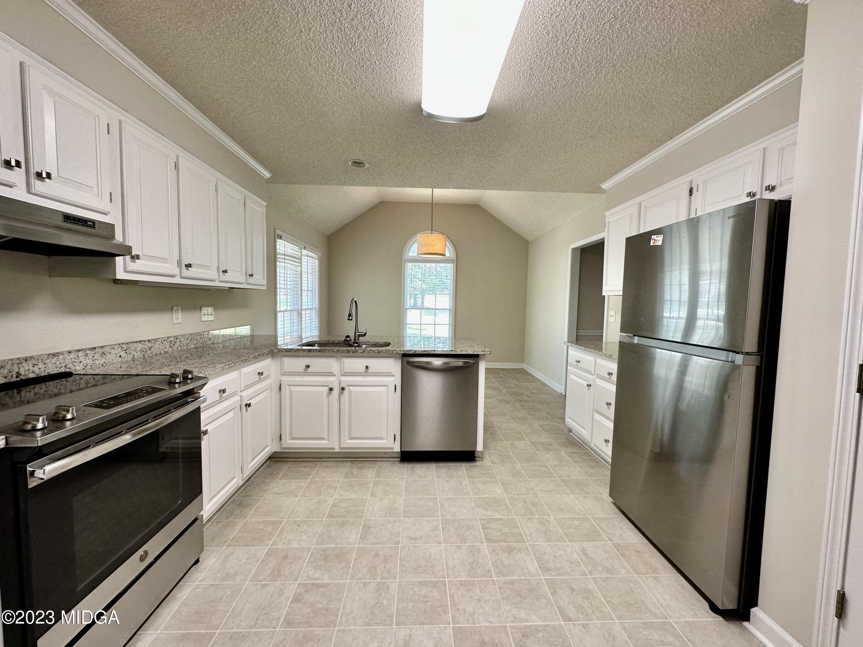 310 Old Oak Road Macon, GA 31216 - Photo 8 of 27 a kitchen with granite countertop a refrigerator and a stove top oven