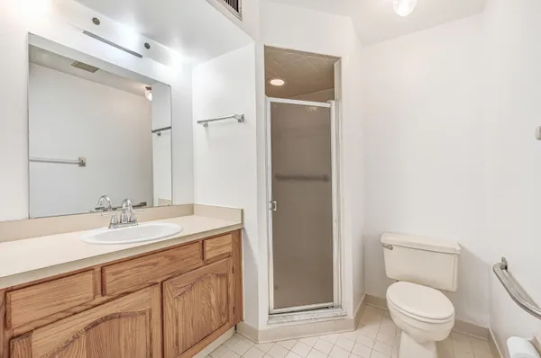 a bathroom with a granite countertop sink toilet and shower