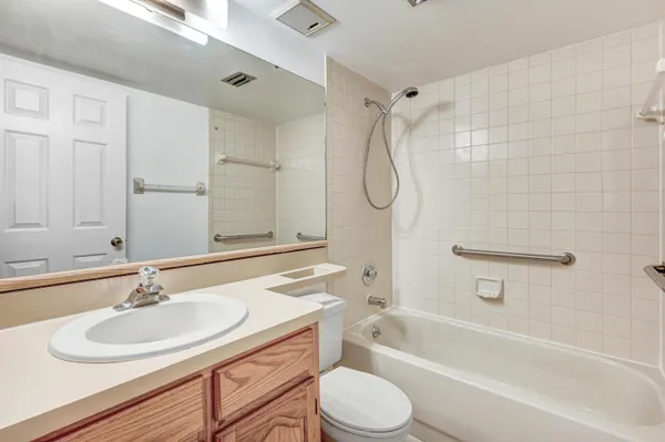 a bathroom with a sink toilet tub vanity and shower