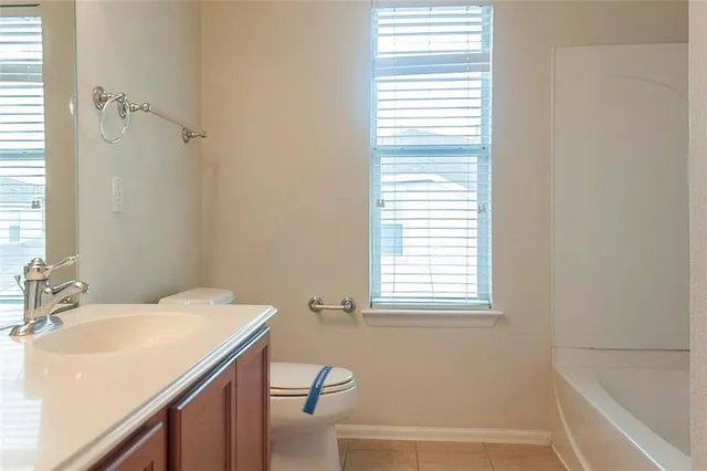 a white toilet sitting next to a white wall