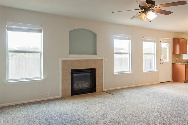 an empty room with windows and fireplace