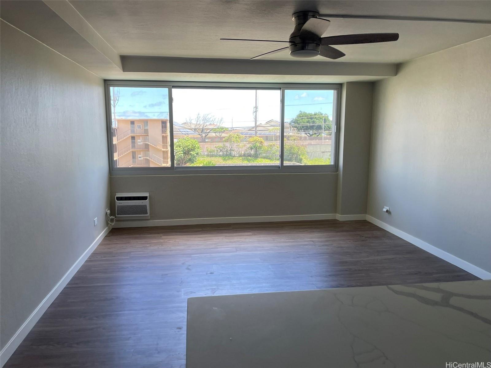 2888 Ala Ilima Street, Unit 910 Honolulu, HI 96818 - Photo 8 of 15 an empty room with wooden floor and windows