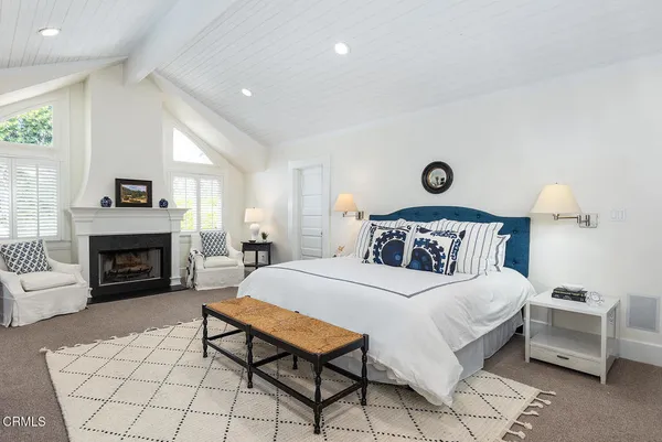 a bedroom with a large bed and a fireplace