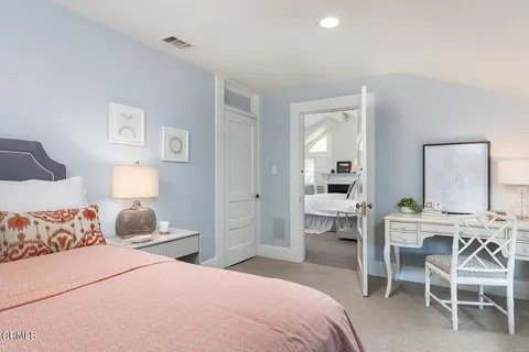 a bedroom with a bed and a lamp on table chair