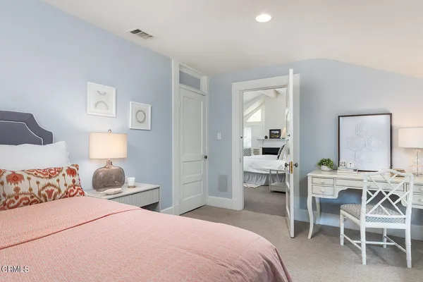 a bedroom with a bed and a lamp on table chair