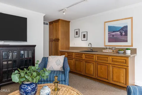 a living room with granite countertop furniture and a flat screen tv