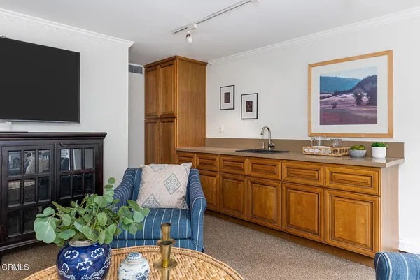 a living room with granite countertop furniture and a flat screen tv