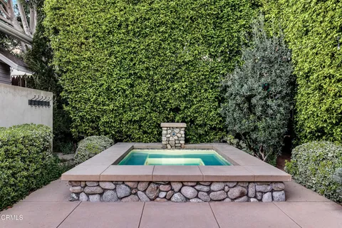 a wooden table sitting in a backyard with swimming pool