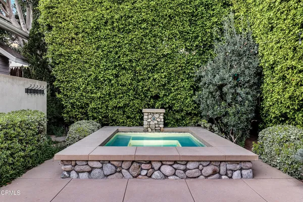 a wooden table sitting in a backyard with swimming pool