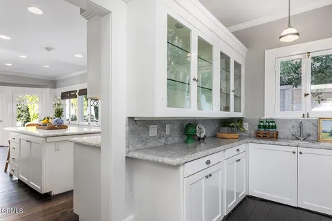 a kitchen with granite countertop a sink and white cabinets
