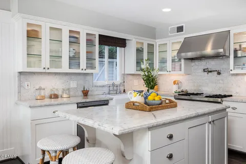 a kitchen with a white cabinets and chairs