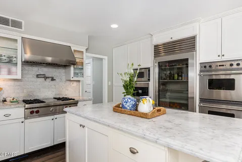 a kitchen with granite countertop a sink cabinets and appliances